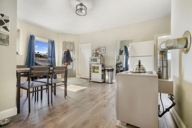 dining space with light wood-style floors and baseboards