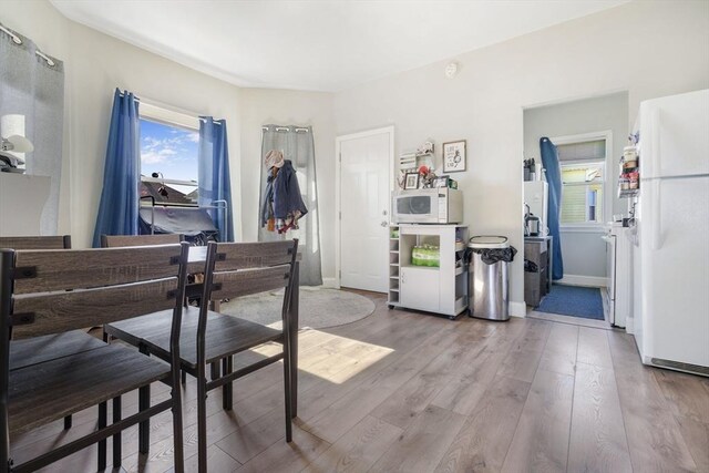 dining room featuring light wood finished floors and baseboards