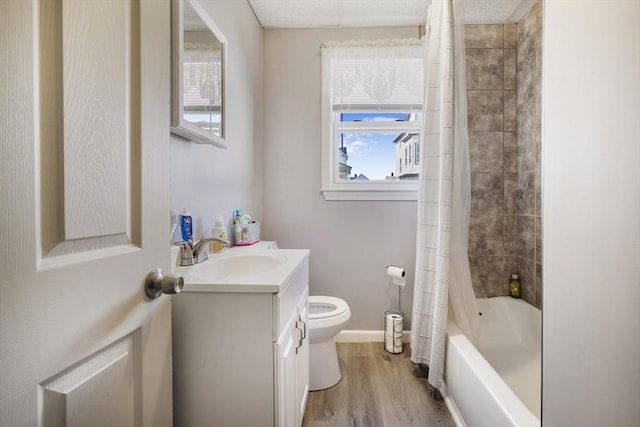 full bathroom featuring toilet, wood finished floors, vanity, baseboards, and shower / bath combo