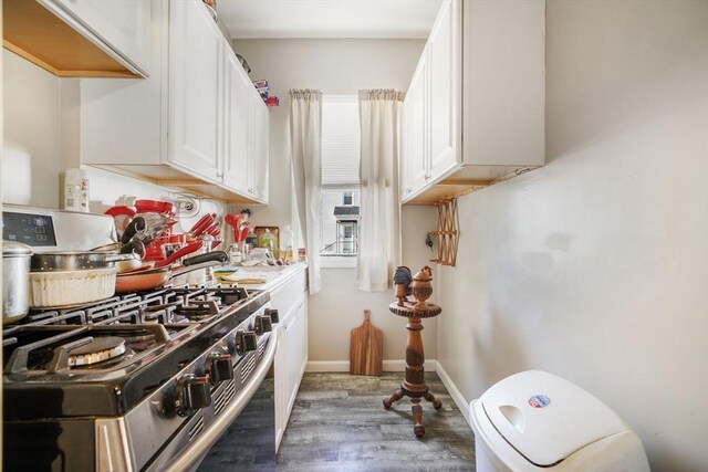 kitchen featuring baseboards, white cabinets, dark wood-style flooring, and gas stove