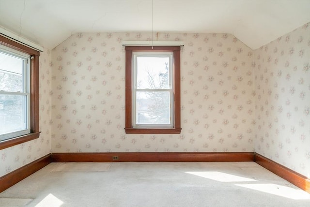 additional living space with lofted ceiling, wallpapered walls, carpet, and baseboards