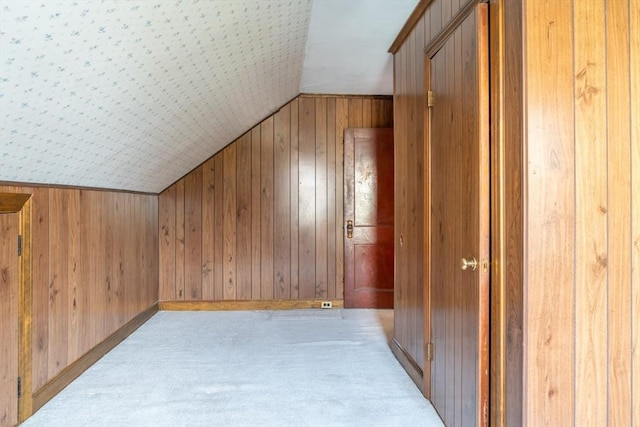 additional living space with wood walls and vaulted ceiling