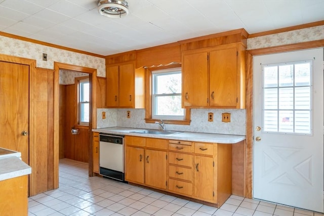 kitchen with a sink, brown cabinetry, light countertops, and dishwasher