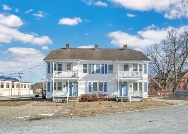 colonial inspired home featuring a porch and a balcony