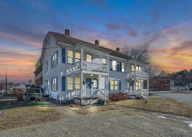 view of front of property featuring a balcony and a lawn