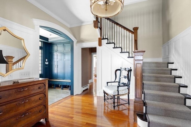 11 Paige St, Hingham, MA 02043 - entryway featuring stairs, wood finished floors, a decorative wall, crown molding, and a baseboard heating unit
