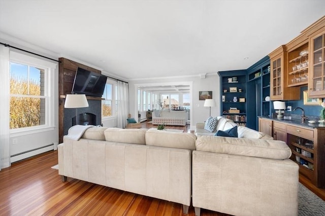 11 Paige St, Hingham, MA 02043 - living area with baseboard heating, wood finished floors, bar, and ornamental molding