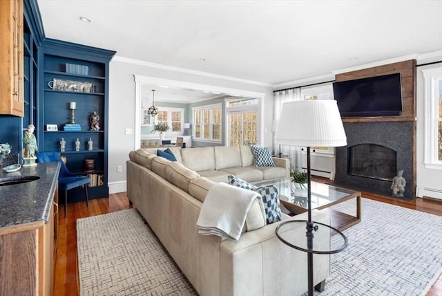 11 Paige St, Hingham, MA 02043 - living area featuring wood finished floors, ornamental molding, baseboard heating, a fireplace, and built in features