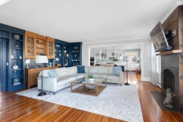 11 Paige St, Hingham, MA 02043 - living area with a fireplace, wood finished floors, crown molding, and baseboard heating