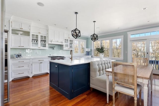 11 Paige St, Hingham, MA 02043 - kitchen featuring dark wood finished floors, light countertops, white cabinetry, glass insert cabinets, and ornamental molding