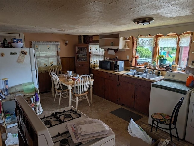 8 May St, Webster, MA 01570 - kitchen with freestanding refrigerator, washer / clothes dryer, light countertops, and brown cabinetry