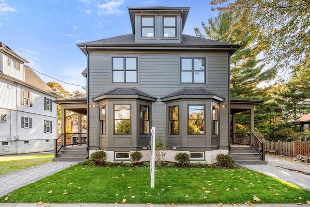 traditional style home featuring covered porch, a front yard, and fence