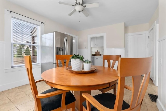 56 Bridge St Unit 56, Beverly, MA 01915 - dining space with light tile patterned flooring, wainscoting, healthy amount of natural light, a ceiling fan, and a decorative wall