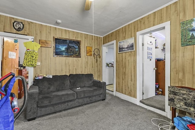carpeted living area featuring ceiling fan, baseboards, ornamental molding, and wooden walls