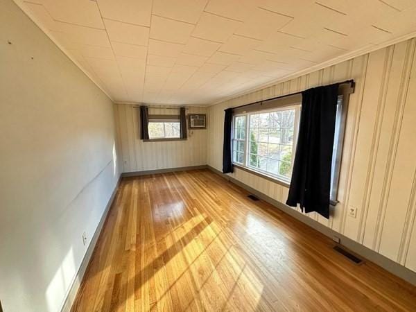 91 W Main St, West Brookfield, MA 01585 - empty room with crown molding, light wood-type flooring, baseboards, visible vents, and a wall unit AC