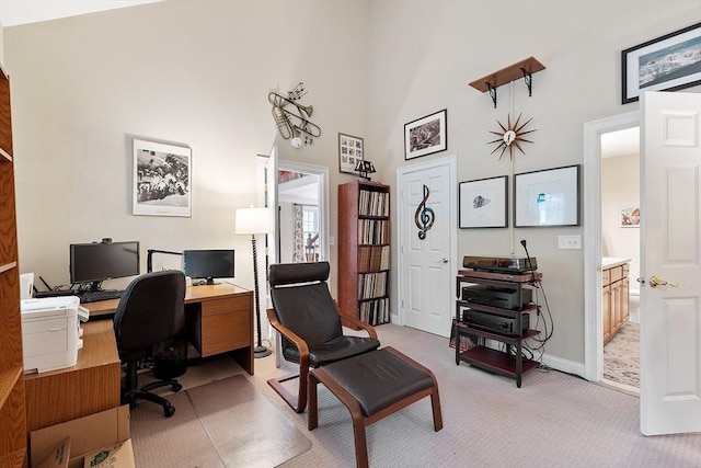 office area with light carpet, high vaulted ceiling, and baseboards
