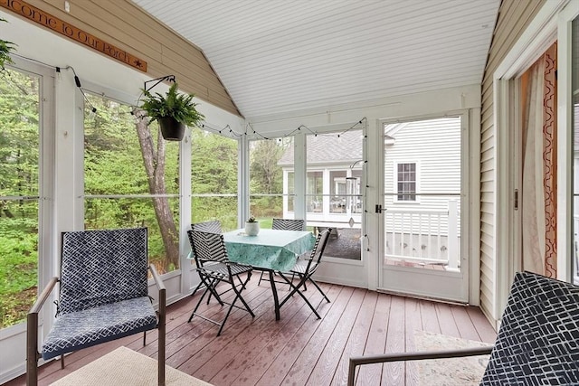 sunroom / solarium with lofted ceiling and outdoor dining space