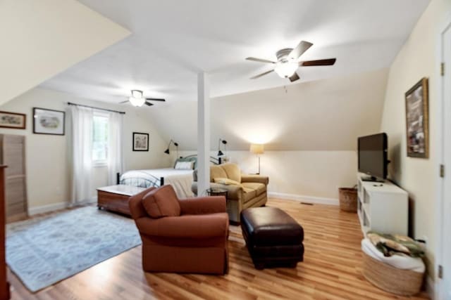 bedroom with light wood-type flooring, lofted ceiling, baseboards, and ceiling fan