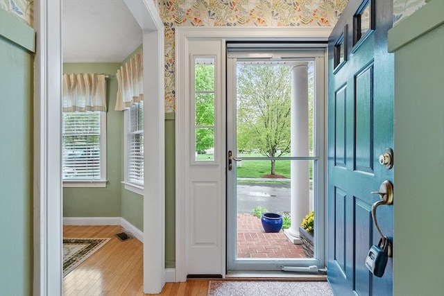 entryway with baseboards and wood finished floors