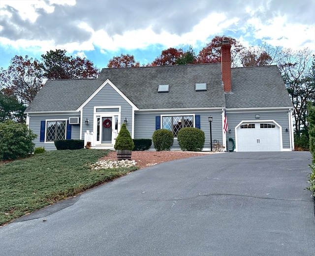 new england style home with a garage and a front lawn