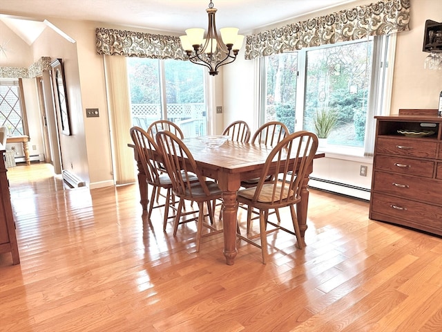 dining space featuring light wood-type flooring, a baseboard radiator, and a chandelier