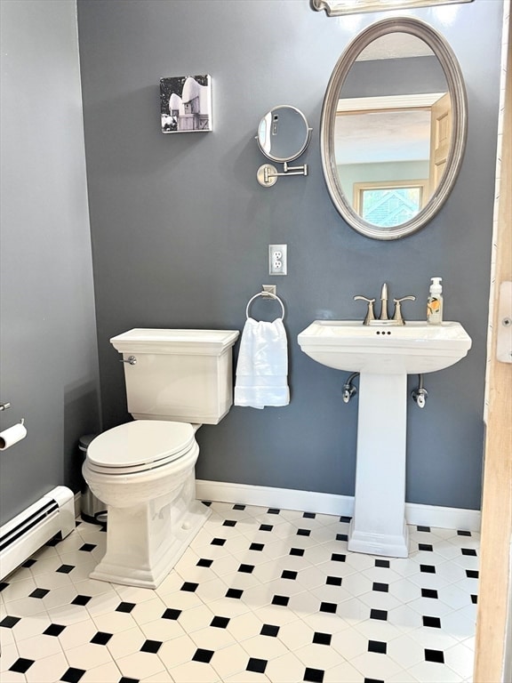 bathroom featuring baseboard heating, sink, and toilet