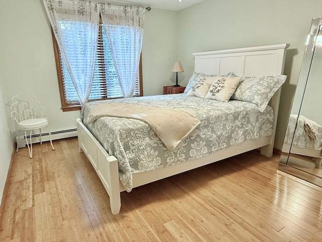 bedroom featuring baseboard heating and light wood-type flooring