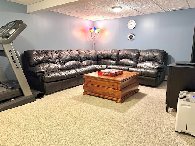 living room with a drop ceiling and carpet floors