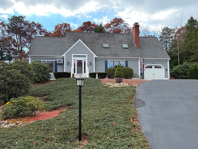 cape cod home featuring a garage and a front yard