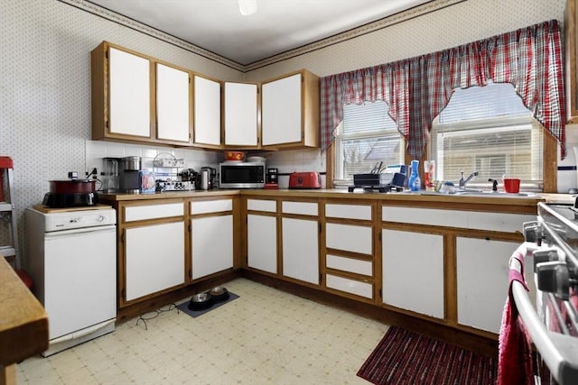 kitchen featuring white cabinetry, ornamental molding, and stove