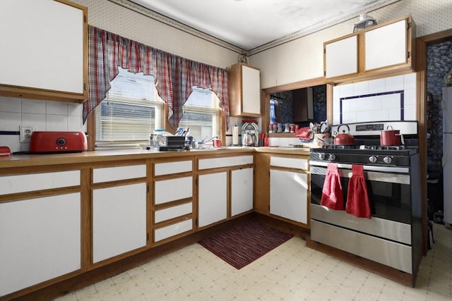 kitchen featuring stainless steel range with gas cooktop and white cabinets