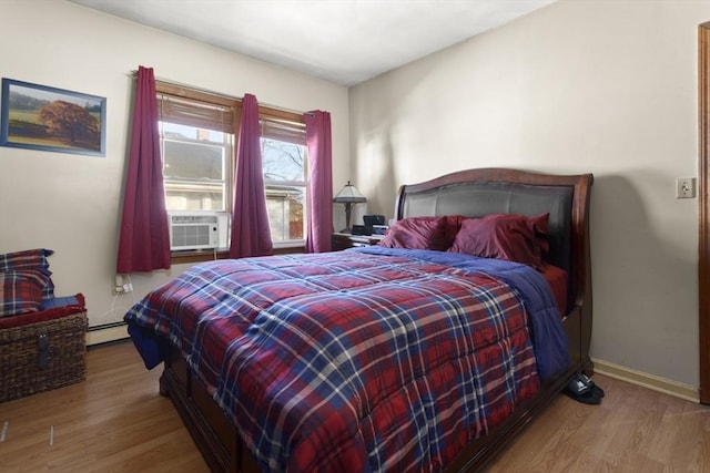 bedroom with light hardwood / wood-style flooring, cooling unit, and a baseboard heating unit