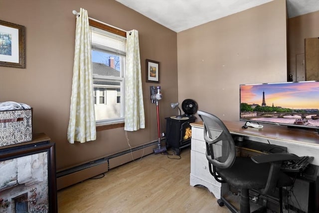 office area with a baseboard radiator and light hardwood / wood-style flooring