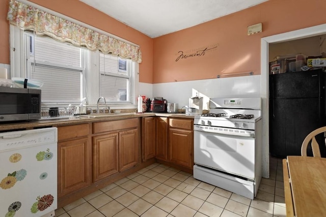 kitchen featuring sink, white appliances, and light tile patterned flooring