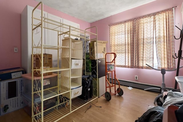 interior space featuring baseboard heating and hardwood / wood-style flooring