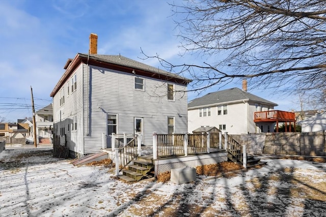 snow covered rear of property featuring a wooden deck