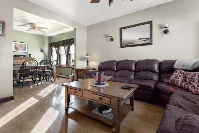 living room featuring wood-type flooring, a baseboard heating unit, and ceiling fan