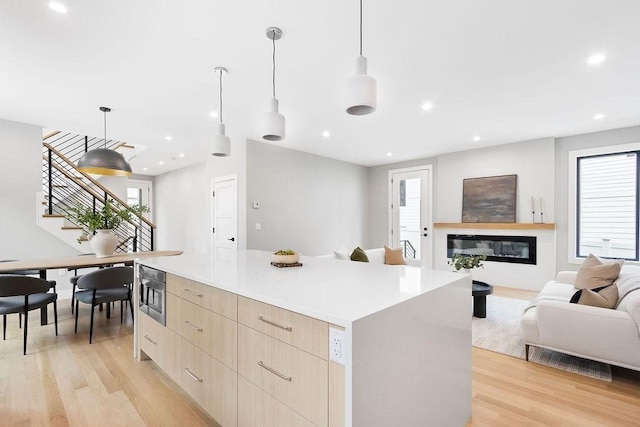 354 Linwood Ave Unit 354, Newton, MA 02460 - kitchen featuring modern cabinets, light brown cabinets, a spacious island, open floor plan, and light wood finished floors