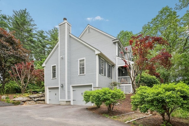 176 Crescent St, Stow, MA 01775 - view of home's exterior with a chimney, asphalt driveway, and an attached garage