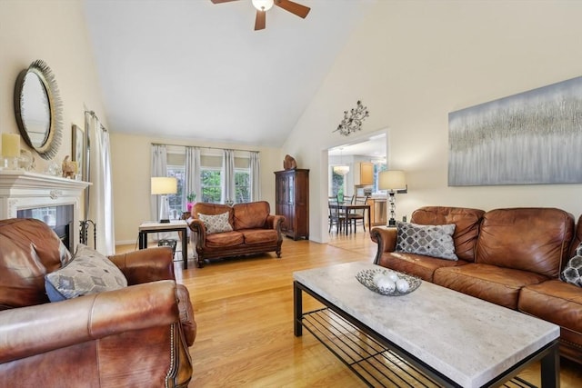 176 Crescent St, Stow, MA 01775 - living area with high vaulted ceiling, a ceiling fan, light wood-style floors, a tile fireplace, and baseboards
