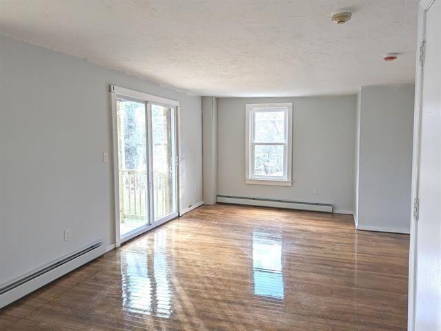 3 S Shore Rd, Salem, NH 03079 - empty room featuring baseboard heating, wood finished floors, and a textured ceiling
