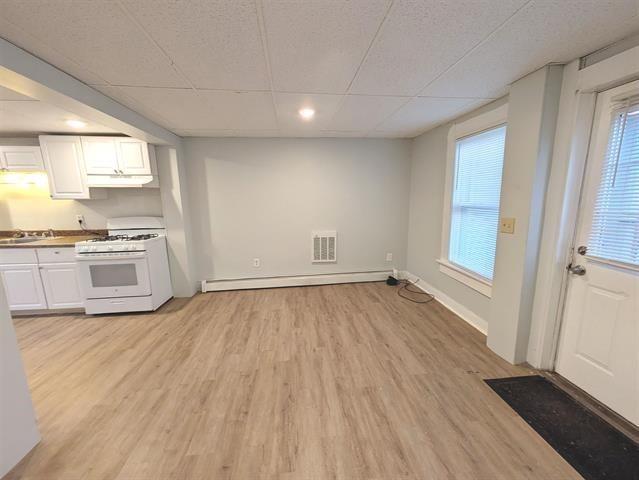 3 S Shore Rd, Salem, NH 03079 - kitchen featuring white range with gas cooktop, a drop ceiling, white cabinetry, under cabinet range hood, and light wood-type flooring
