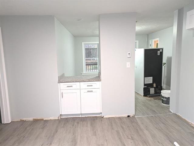 3 S Shore Rd, Salem, NH 03079 - kitchen with light wood-style flooring, white cabinets, and light stone counters