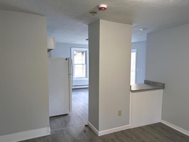 3 S Shore Rd, Salem, NH 03079 - hallway featuring wood finished floors, a baseboard heating unit, and a textured ceiling
