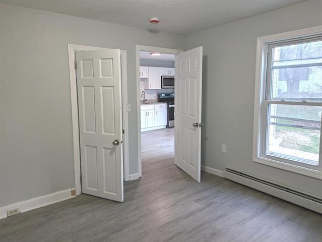 3 S Shore Rd, Salem, NH 03079 - unfurnished room with a baseboard radiator and light wood-style floors