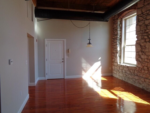 12 Brookside Rd Unit 20, Westford, MA 01886 - empty room with wood finished floors, beam ceiling, a towering ceiling, baseboards, and plenty of natural light