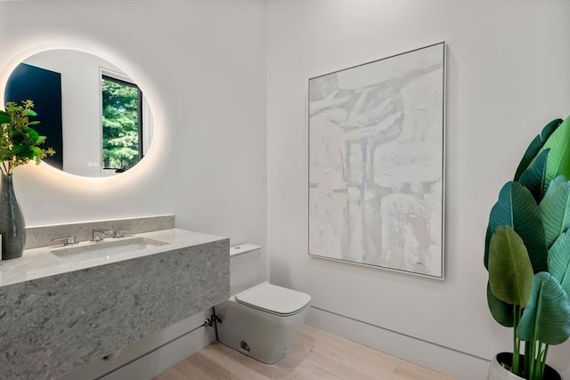 bathroom featuring hardwood / wood-style flooring, toilet, and sink