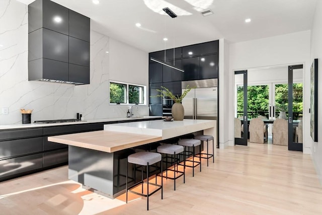 kitchen with decorative light fixtures, tasteful backsplash, a kitchen breakfast bar, a center island, and stainless steel appliances