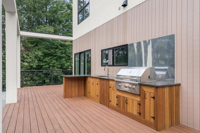 deck with exterior kitchen, a grill, and sink