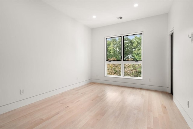 empty room with a healthy amount of sunlight and light hardwood / wood-style floors